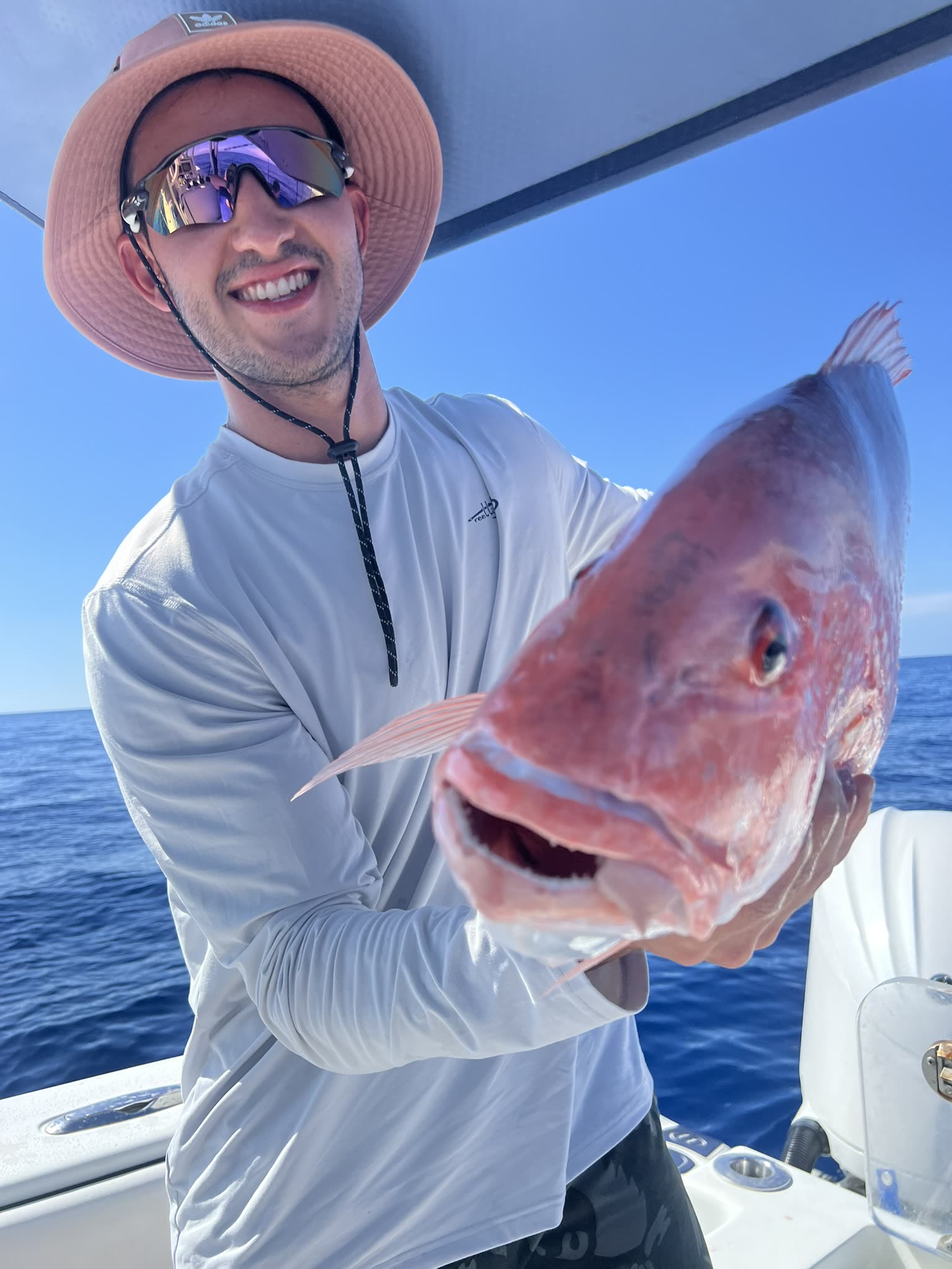 Close-up of a red snapper at the boat rail, deep red with a large dark eye